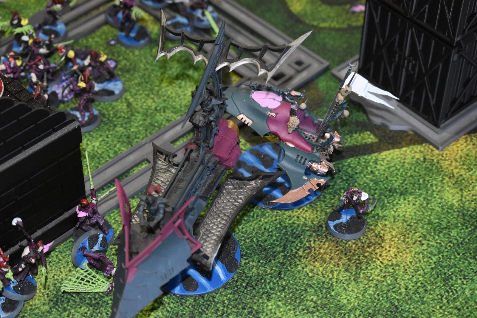 A painted Warhammer 40K vehicle leading an army across a green battlefield
