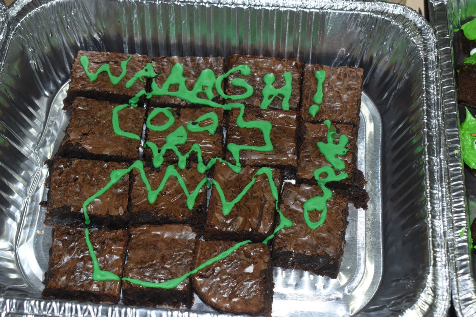 A tray of brownies iced with WAAAGH! in green frosting at OrktoberFest III